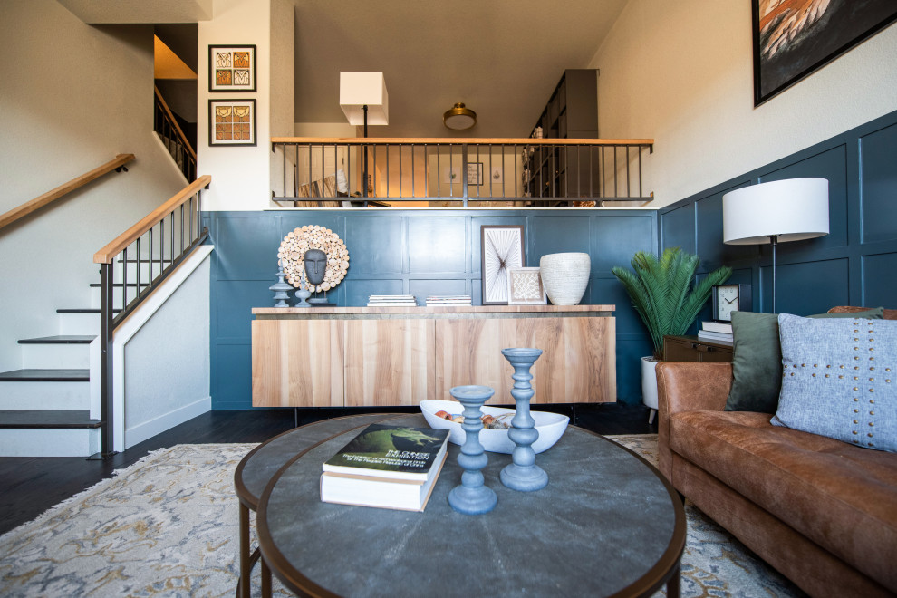 Cette image montre une salle de séjour mansardée ou avec mezzanine minimaliste de taille moyenne avec un mur bleu, parquet foncé, un sol marron et du lambris.