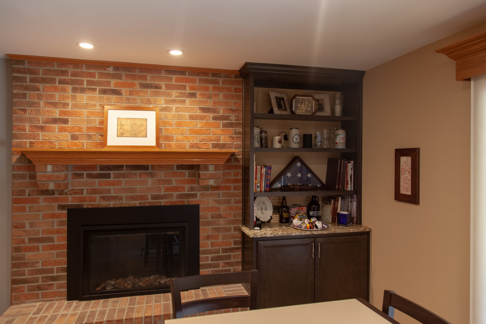 Large transitional walk-out carpeted and beige floor basement photo in Cincinnati with beige walls, a standard fireplace and a brick fireplace