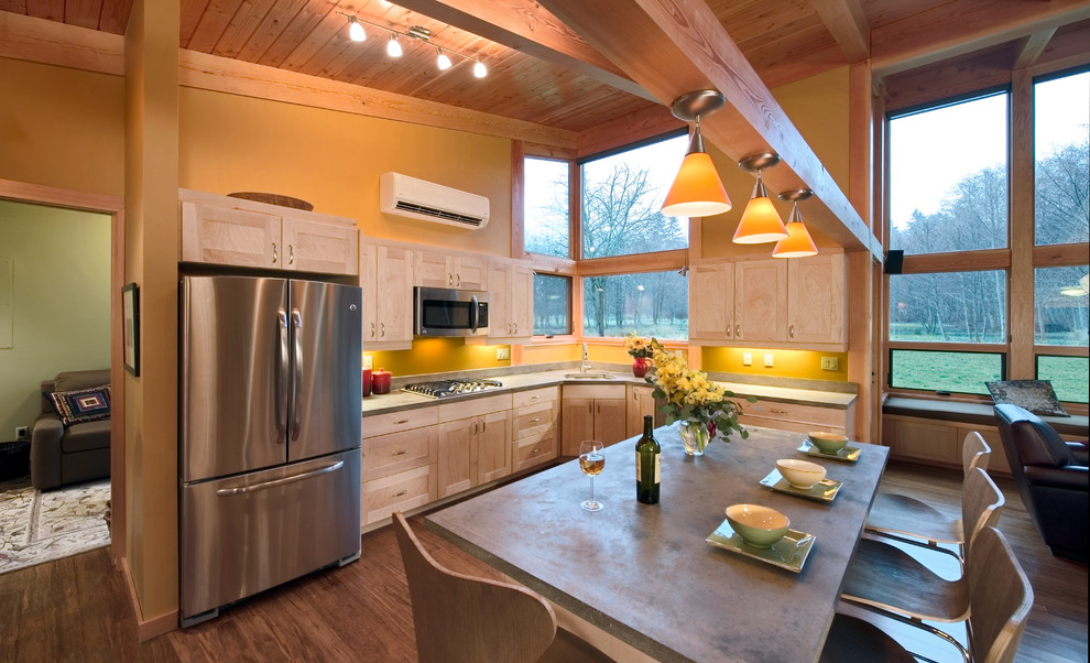 Mid-sized contemporary l-shaped open plan kitchen in Seattle with concrete benchtops, shaker cabinets, light wood cabinets, stainless steel appliances, an undermount sink, medium hardwood floors, with island and brown floor.