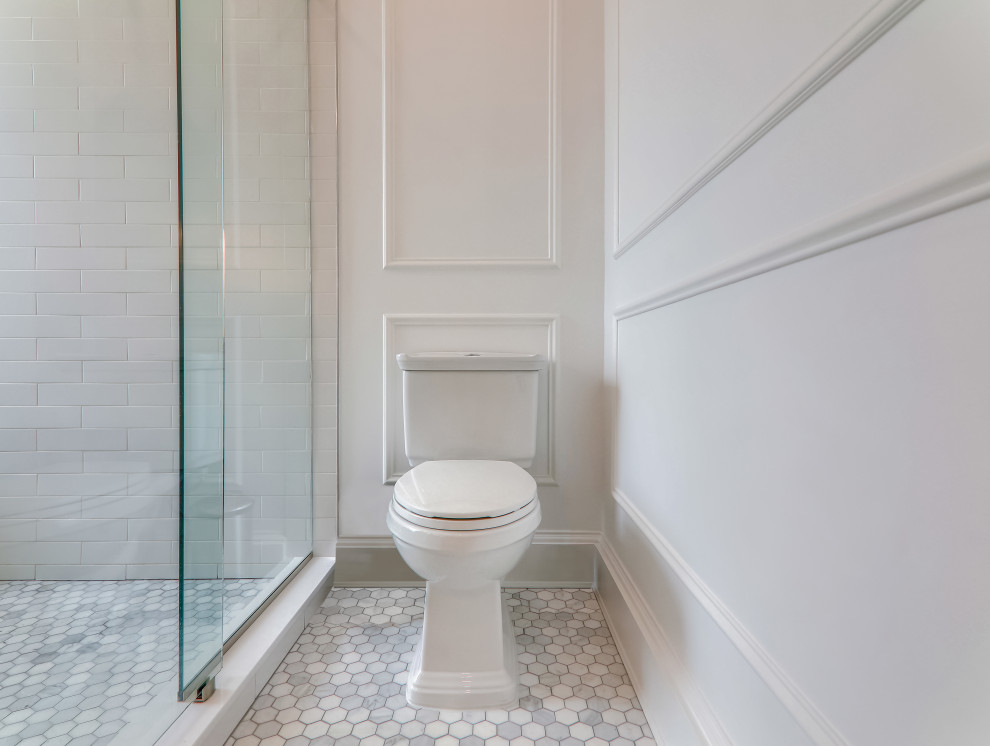 Photo of a mid-sized contemporary master bathroom in DC Metro with louvered cabinets, light wood cabinets, a drop-in tub, a two-piece toilet, white tile, ceramic tile, white walls, ceramic floors, an undermount sink, marble benchtops, white floor, a sliding shower screen, white benchtops, a niche, a double vanity, a freestanding vanity and panelled walls.