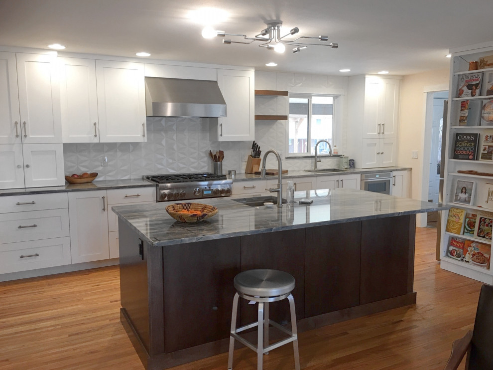 This is an example of a large transitional single-wall open plan kitchen in Denver with an undermount sink, shaker cabinets, white cabinets, quartz benchtops, white splashback, stainless steel appliances, with island and grey benchtop.