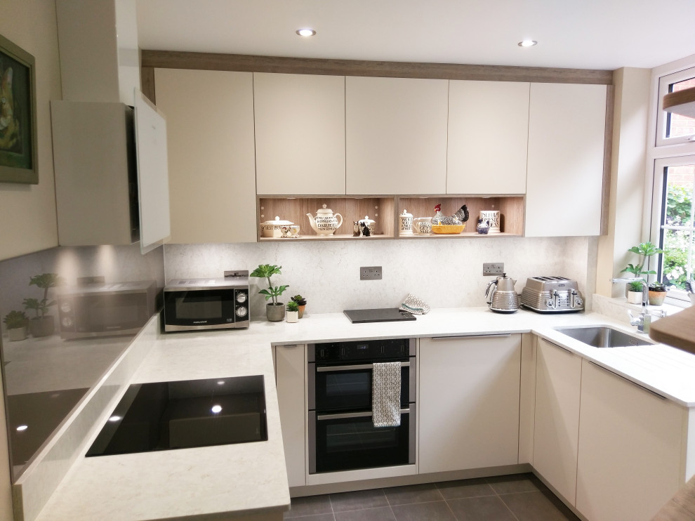 Small contemporary galley kitchen pantry in London with a single-bowl sink, shaker cabinets, beige cabinets, concrete benchtops, white splashback, ceramic splashback, white appliances, marble floors, grey floor, beige benchtop and wood.