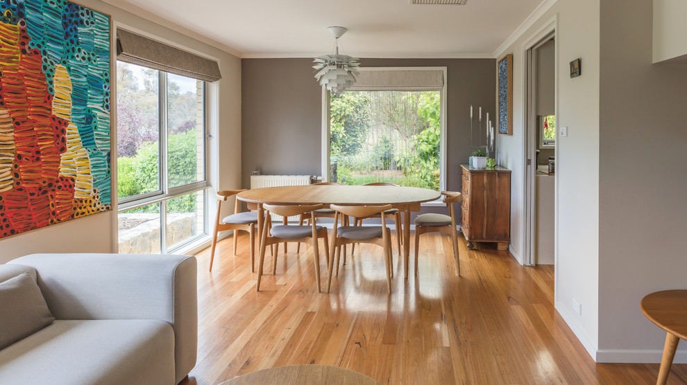Inspiration for a scandinavian dining room in Canberra - Queanbeyan with grey walls, medium hardwood floors, no fireplace and brown floor.