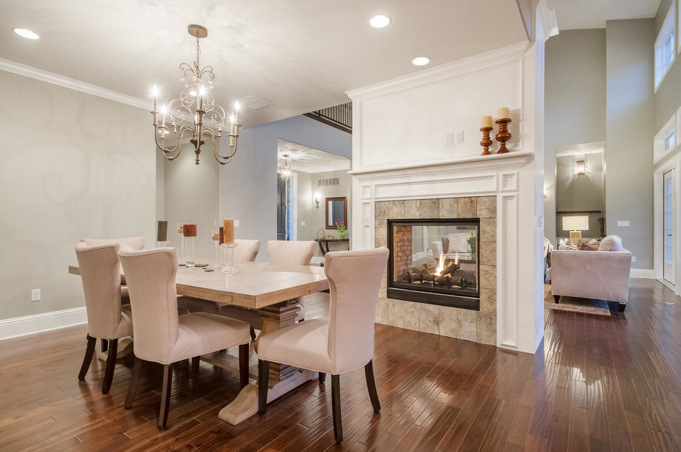 Mid-sized transitional kitchen/dining combo in Denver with grey walls, dark hardwood floors, a two-sided fireplace and a plaster fireplace surround.