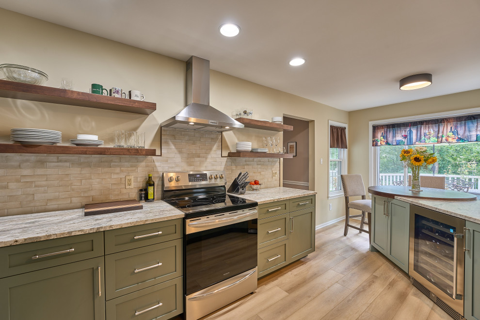 Inspiration for a mid-sized contemporary u-shaped kitchen in Philadelphia with a drop-in sink, recessed-panel cabinets, green cabinets, granite benchtops, beige splashback, subway tile splashback, stainless steel appliances, laminate floors, with island, brown floor and white benchtop.