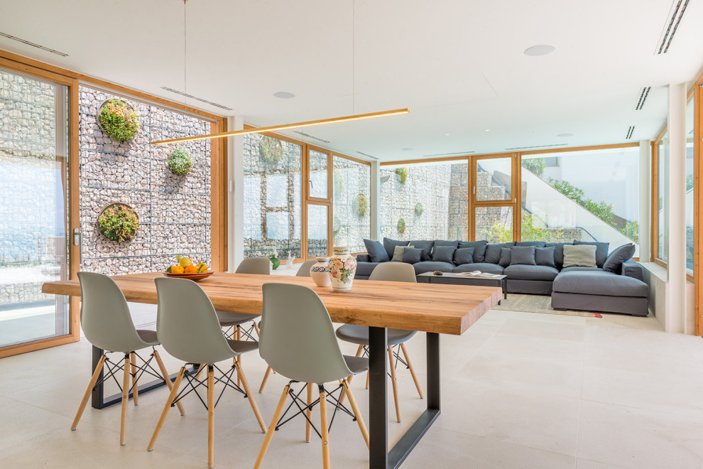 Idee per una grande sala da pranzo aperta verso il soggiorno mediterranea con pareti bianche e pavimento beige