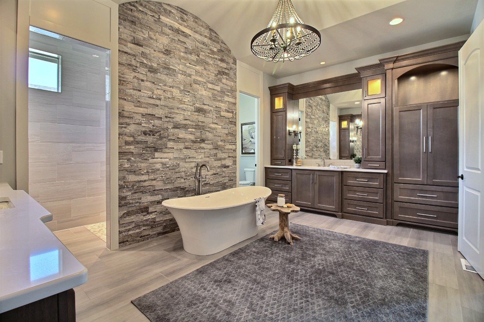 Expansive arts and crafts master bathroom in Portland with recessed-panel cabinets, dark wood cabinets, a freestanding tub, a curbless shower, a one-piece toilet, gray tile, ceramic tile, grey walls, ceramic floors, an undermount sink, engineered quartz benchtops, grey floor, an open shower and white benchtops.