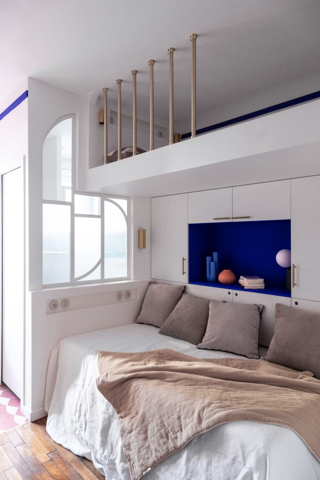 Foto di un piccolo soggiorno moderno aperto con libreria, pareti blu, pavimento in legno massello medio e pavimento marrone