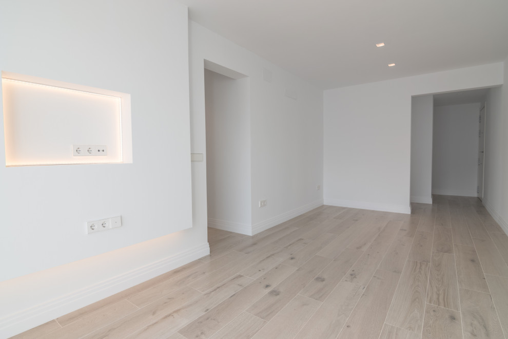 Modelo de salón cerrado nórdico pequeño con paredes blancas, suelo de baldosas de porcelana, pared multimedia y suelo beige