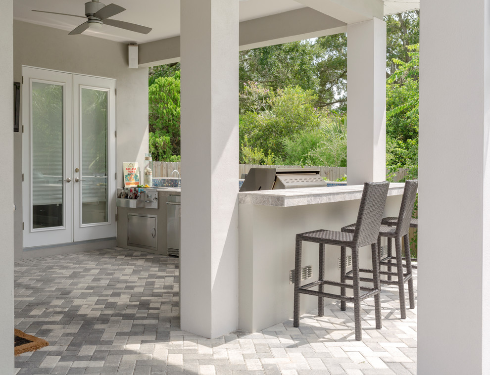 Design ideas for a mid-sized transitional backyard patio in Tampa with an outdoor kitchen, brick pavers and a roof extension.