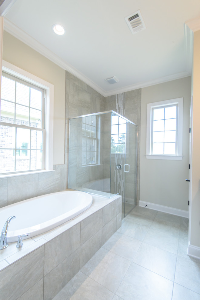 Mid-sized traditional master bathroom in Other with a drop-in tub, a corner shower, gray tile, porcelain tile, beige walls, porcelain floors, grey floor and a hinged shower door.