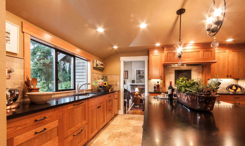 Photo of a large transitional open plan kitchen in Seattle with an undermount sink, shaker cabinets, medium wood cabinets, solid surface benchtops, beige splashback, stone tile splashback, stainless steel appliances, porcelain floors, with island and beige floor.