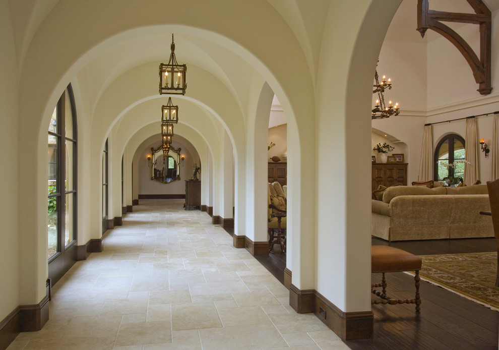 This is an example of a mediterranean hallway in Denver with white walls and beige floor.