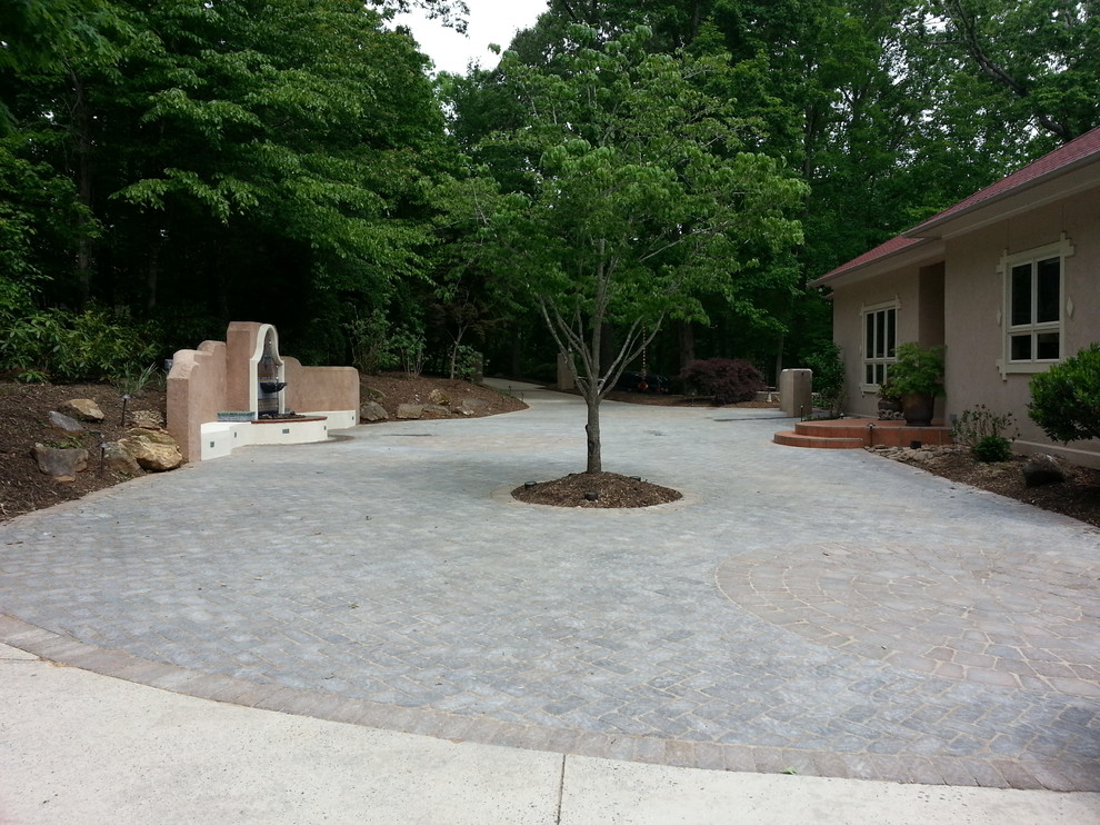 Photo of a large front yard partial sun driveway in Raleigh with a water feature and concrete pavers.