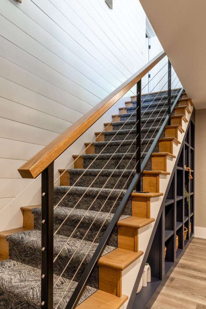 Cette photo montre un escalier droit chic de taille moyenne avec des marches en moquette, un garde-corps en métal, du lambris de bois et rangements.