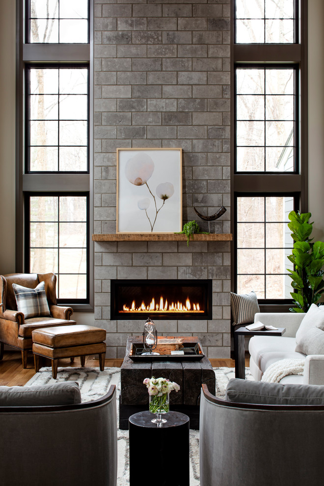 Photo of a transitional living room in Baltimore with beige walls, medium hardwood floors, a ribbon fireplace, a tile fireplace surround and brown floor.