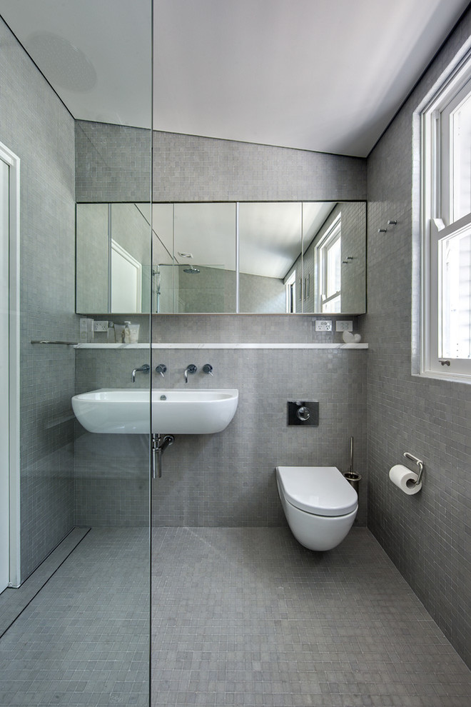 Inspiration for a mid-sized modern master bathroom in Sydney with a wall-mount sink, flat-panel cabinets, granite benchtops, an open shower, a wall-mount toilet, gray tile, ceramic tile, white walls and ceramic floors.