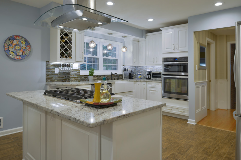 Inspiration for a mid-sized contemporary u-shaped laminate floor and brown floor eat-in kitchen remodel with an undermount sink, raised-panel cabinets, white cabinets, granite countertops, multicolored backsplash, matchstick tile backsplash, stainless steel appliances and a peninsula