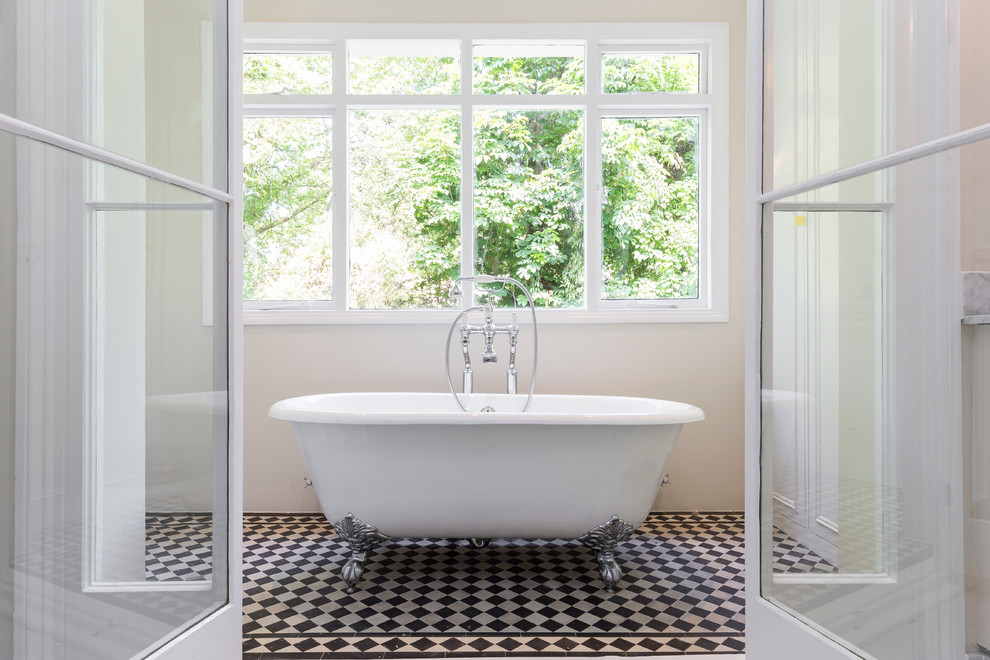 Traditional bathroom in London with a freestanding tub and beige walls.