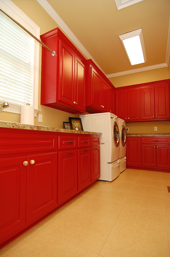 Large traditional u-shaped laundry room in Charleston with a drop-in sink, raised-panel cabinets, red cabinets, laminate benchtops, brown walls, ceramic floors, a side-by-side washer and dryer and beige floor.