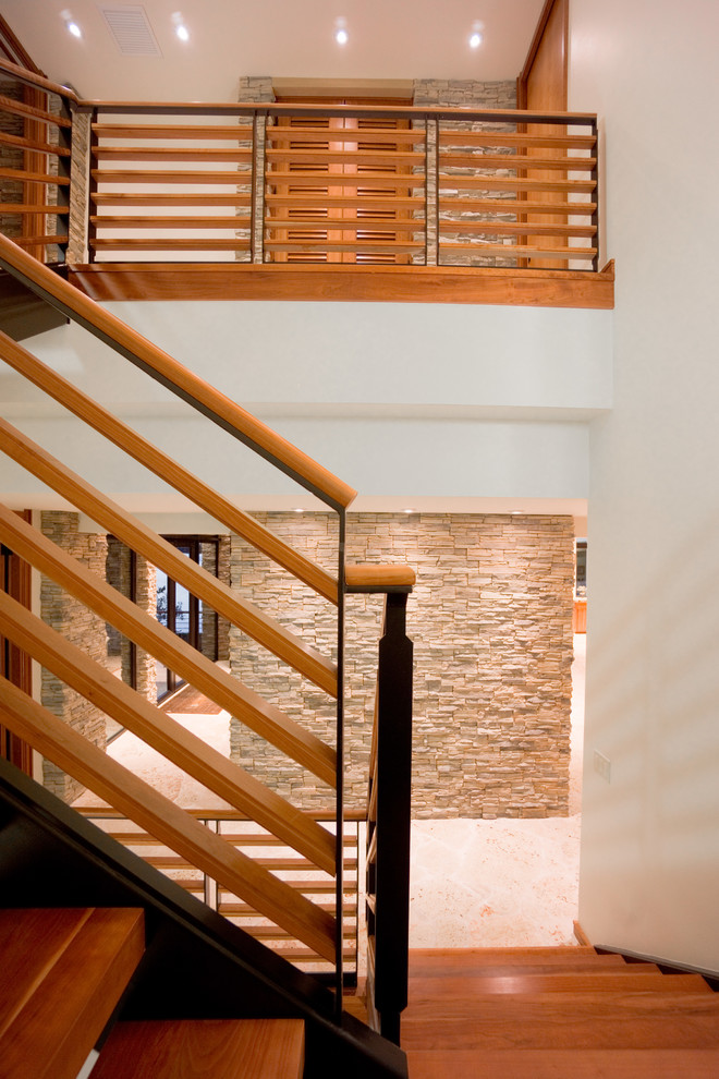 Photo of a large midcentury wood u-shaped staircase in Tampa with open risers.