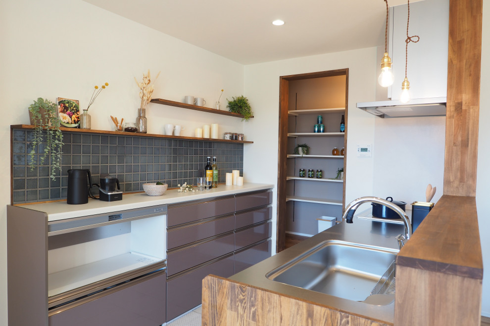 Foto di una cucina ad ambiente unico industriale con ante marroni, paraspruzzi marrone, elettrodomestici in acciaio inossidabile, pavimento in vinile, pavimento beige e soffitto in carta da parati