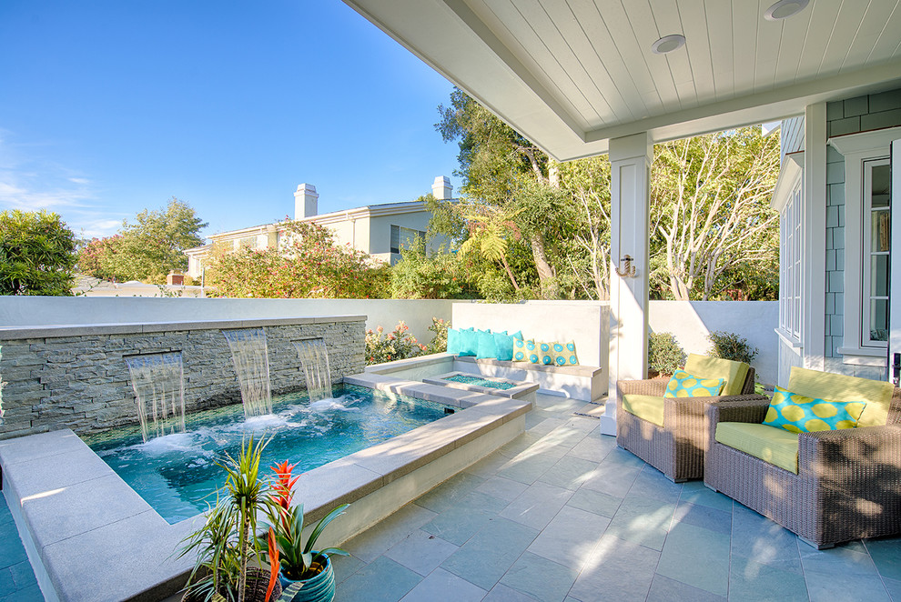 Photo of a mid-sized beach style backyard rectangular pool in Los Angeles with a hot tub and natural stone pavers.