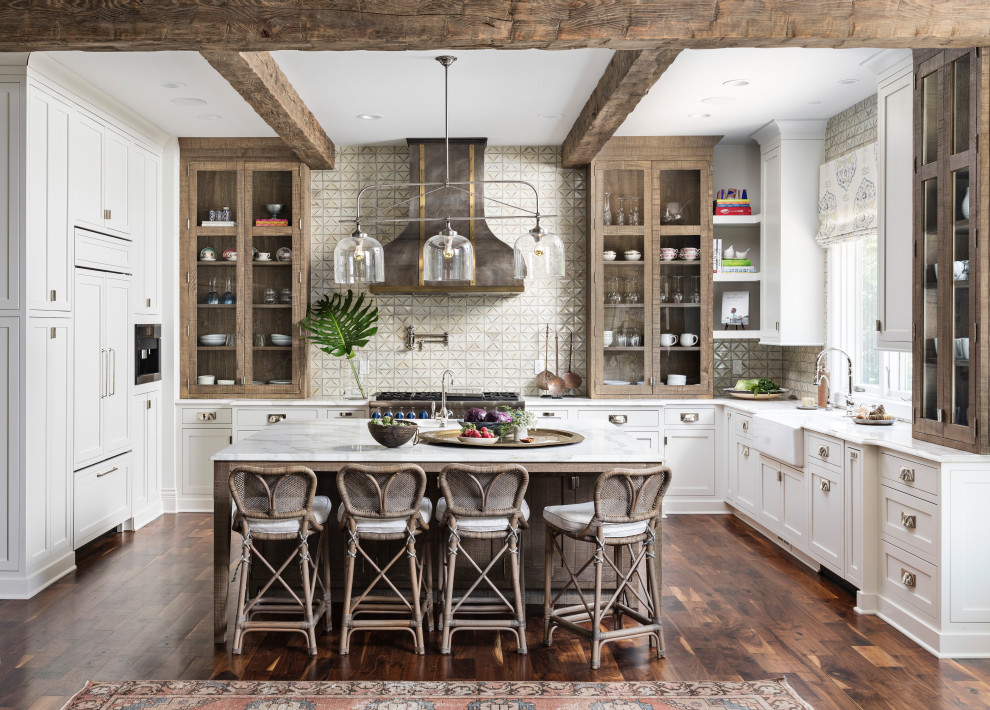 Transitional u-shaped dark wood floor and brown floor kitchen photo in Detroit with a farmhouse sink, shaker cabinets, white cabinets, beige backsplash, stainless steel appliances, an island and white countertops