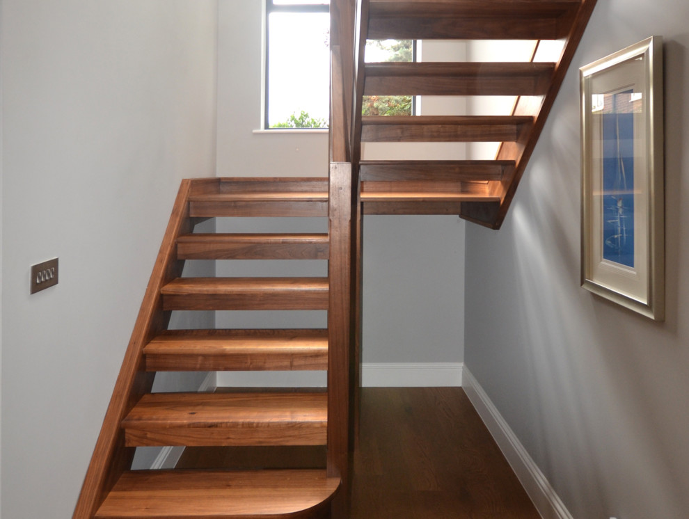 This is an example of a modern u-shaped staircase in Sussex with glass railing.