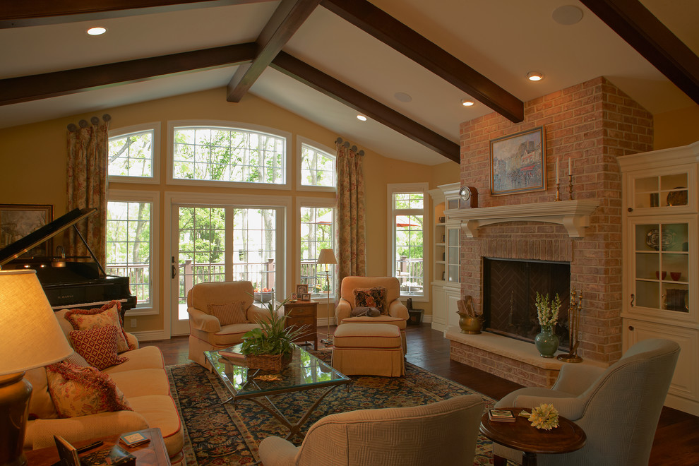 Large traditional formal open concept living room in Other with white walls, dark hardwood floors, a standard fireplace, a brick fireplace surround and a built-in media wall.