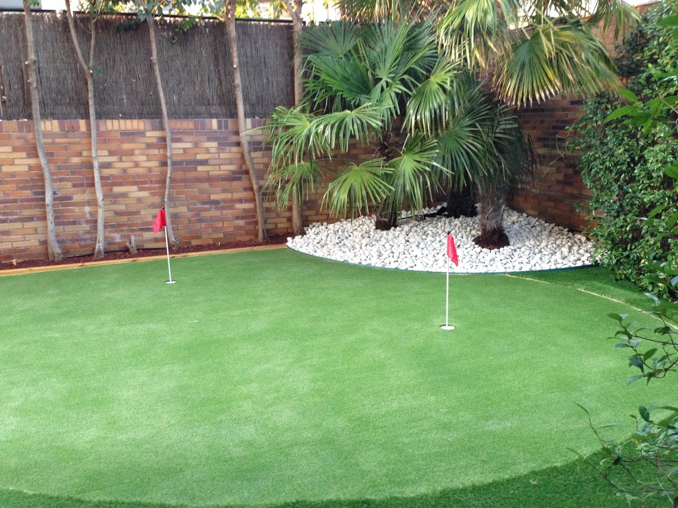 Imagen de pista deportiva descubierta mediterránea de tamaño medio en patio trasero con exposición parcial al sol