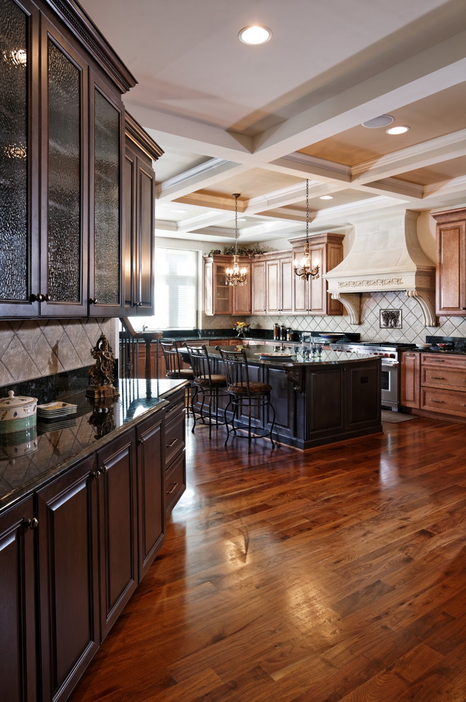 This is an example of an expansive traditional u-shaped separate kitchen in DC Metro with an undermount sink, raised-panel cabinets, medium wood cabinets, marble benchtops, beige splashback, limestone splashback, stainless steel appliances, medium hardwood floors, with island, brown floor and green benchtop.
