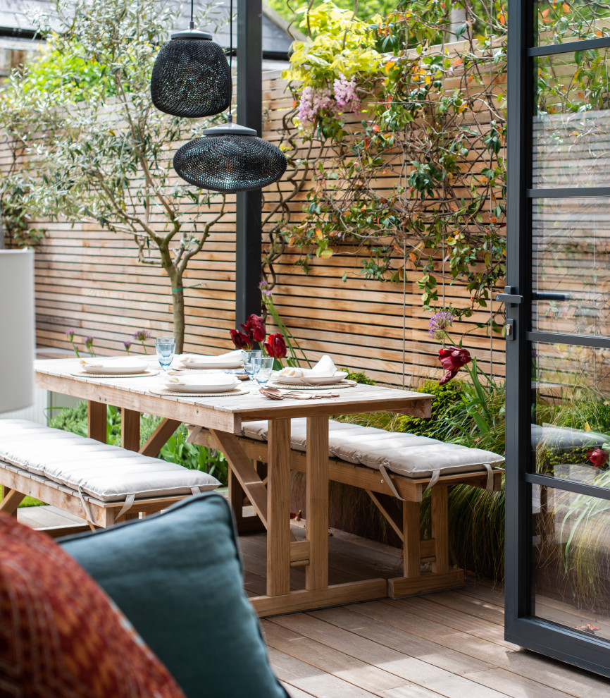 This is an example of a small contemporary formal and private full sun garden for spring in London with decking.