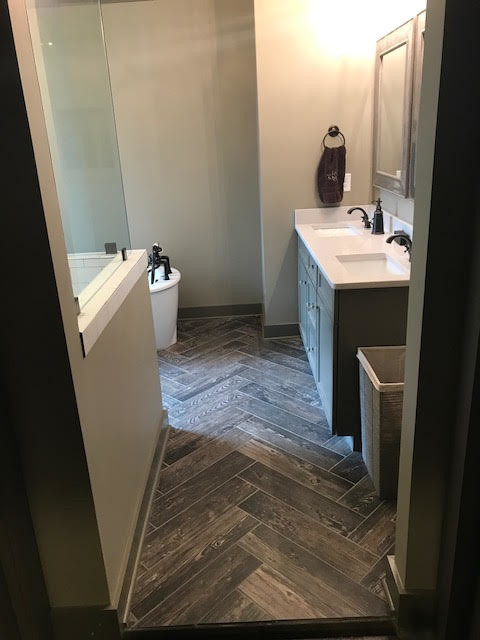 Large transitional master bathroom in Birmingham with shaker cabinets, grey cabinets, a freestanding tub, a corner shower, a two-piece toilet, white tile, subway tile, beige walls, laminate floors, a pedestal sink, solid surface benchtops, grey floor, a hinged shower door and white benchtops.