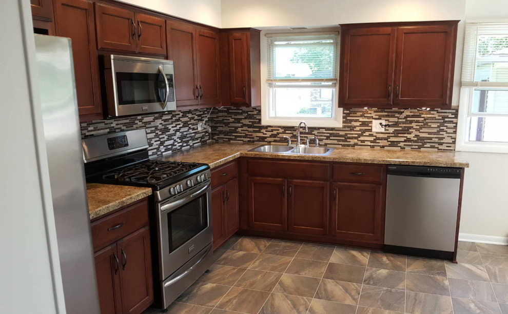Small transitional l-shaped laminate floor and multicolored floor eat-in kitchen photo with a double-bowl sink, recessed-panel cabinets, dark wood cabinets, granite countertops, multicolored backsplash, matchstick tile backsplash, stainless steel appliances, no island and beige countertops