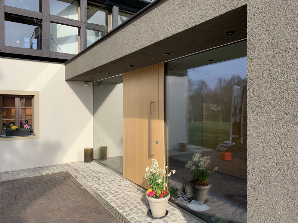 Moderne Haustür mit Drehtür und hellbrauner Holzhaustür in München
