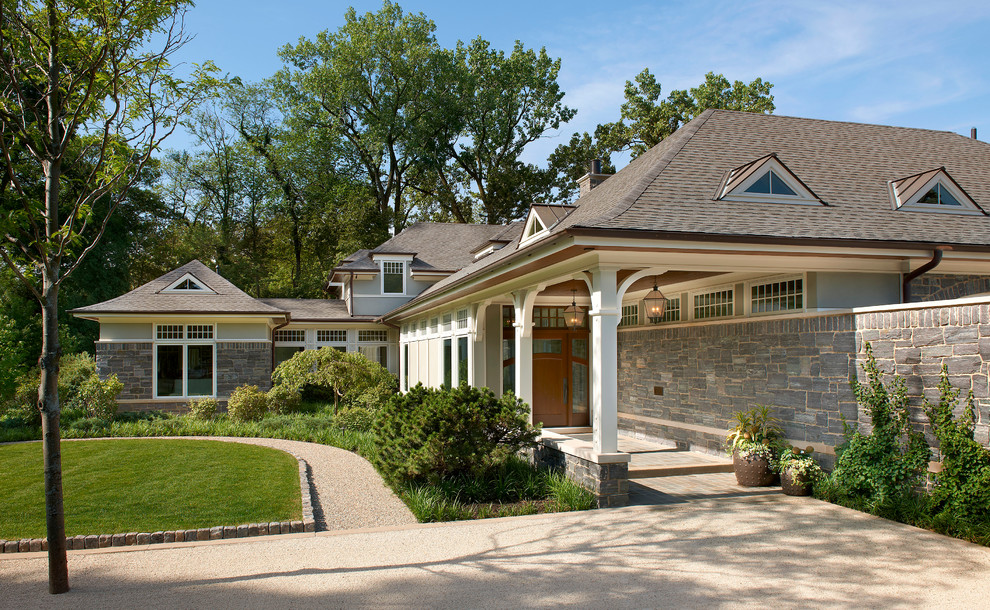 Photo of a large traditional two-storey grey exterior in Chicago with mixed siding and a clipped gable roof.