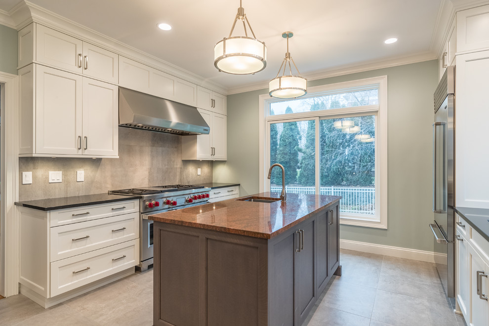 Example of a large transitional galley ceramic tile and gray floor open concept kitchen design in Bridgeport with an undermount sink, recessed-panel cabinets, white cabinets, granite countertops, gray backsplash, ceramic backsplash, stainless steel appliances, two islands and black countertops