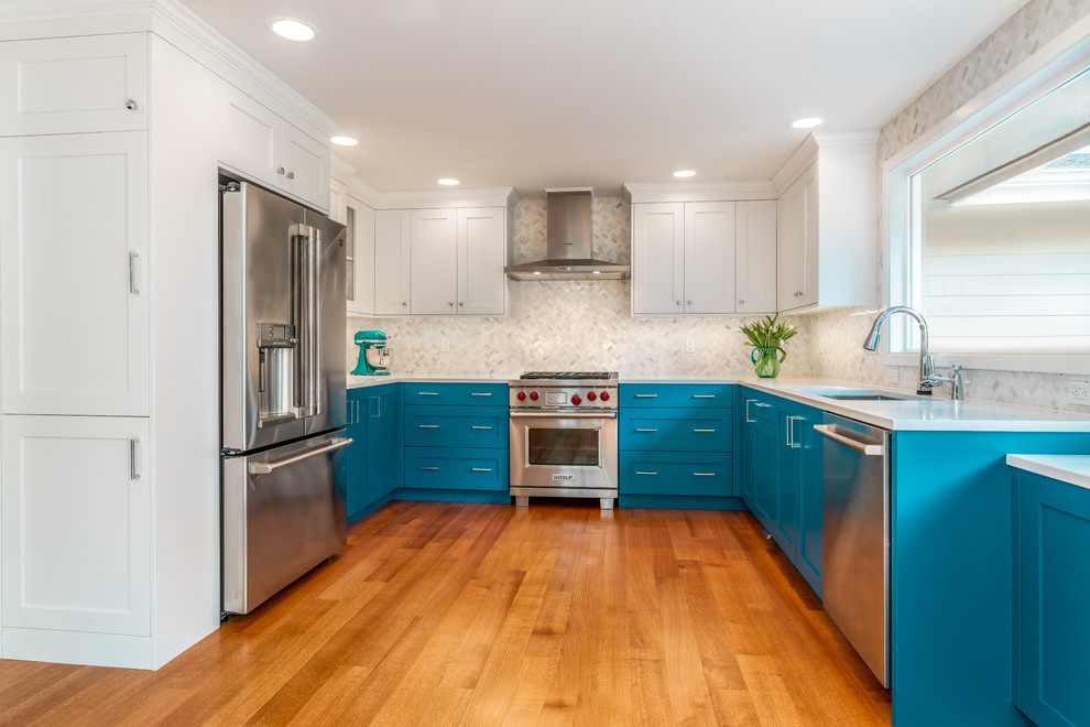 Small transitional u-shaped light wood floor kitchen pantry photo in Seattle with an undermount sink, shaker cabinets, blue cabinets, quartz countertops, white backsplash, marble backsplash, stainless steel appliances and white countertops