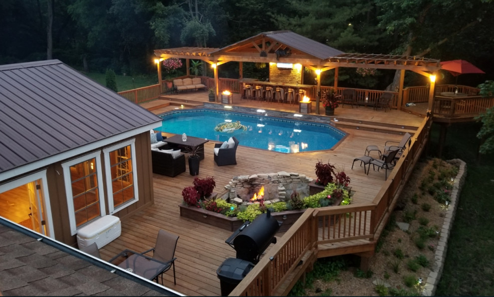 This is an example of a large arts and crafts backyard custom-shaped aboveground pool in Chicago with decking.