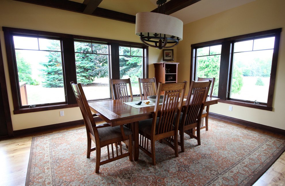 Photo of a mid-sized arts and crafts separate dining room in Milwaukee with beige walls, medium hardwood floors and no fireplace.