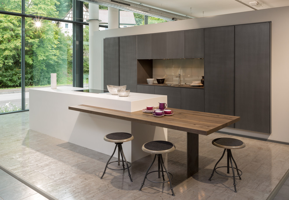 Inspiration for a large contemporary single-wall open plan kitchen in Oxfordshire with an undermount sink, flat-panel cabinets, beige cabinets, quartz benchtops, metallic splashback, glass tile splashback, black appliances, cement tiles and with island.