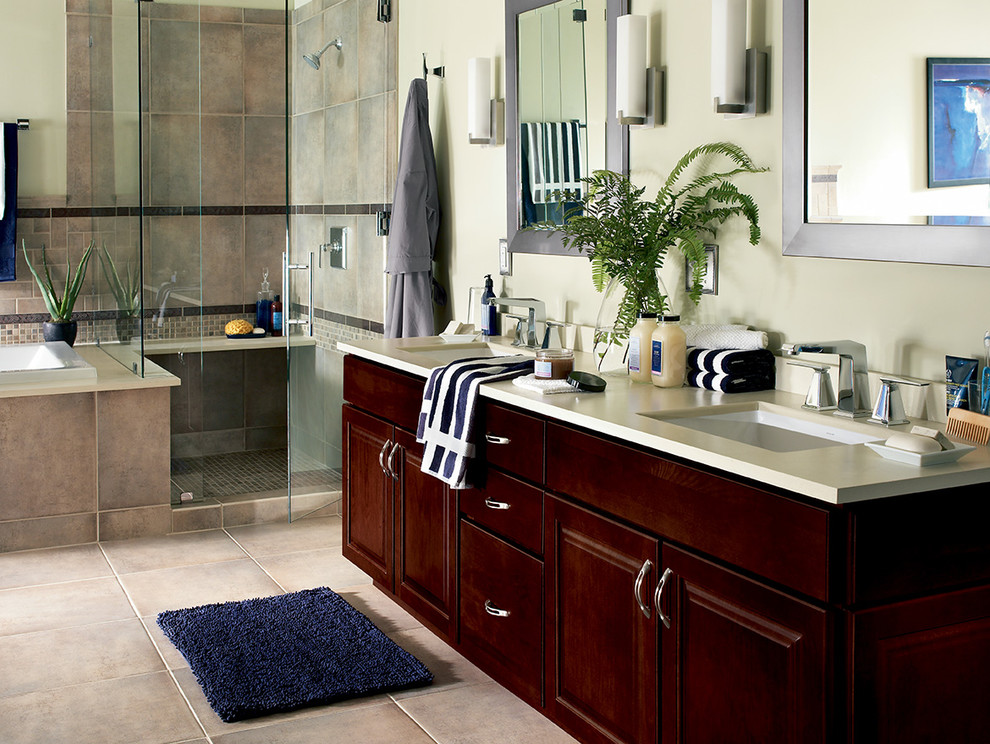 Inspiration for a traditional master bathroom in Kansas City with a drop-in sink, recessed-panel cabinets, dark wood cabinets, solid surface benchtops, white walls and ceramic floors.