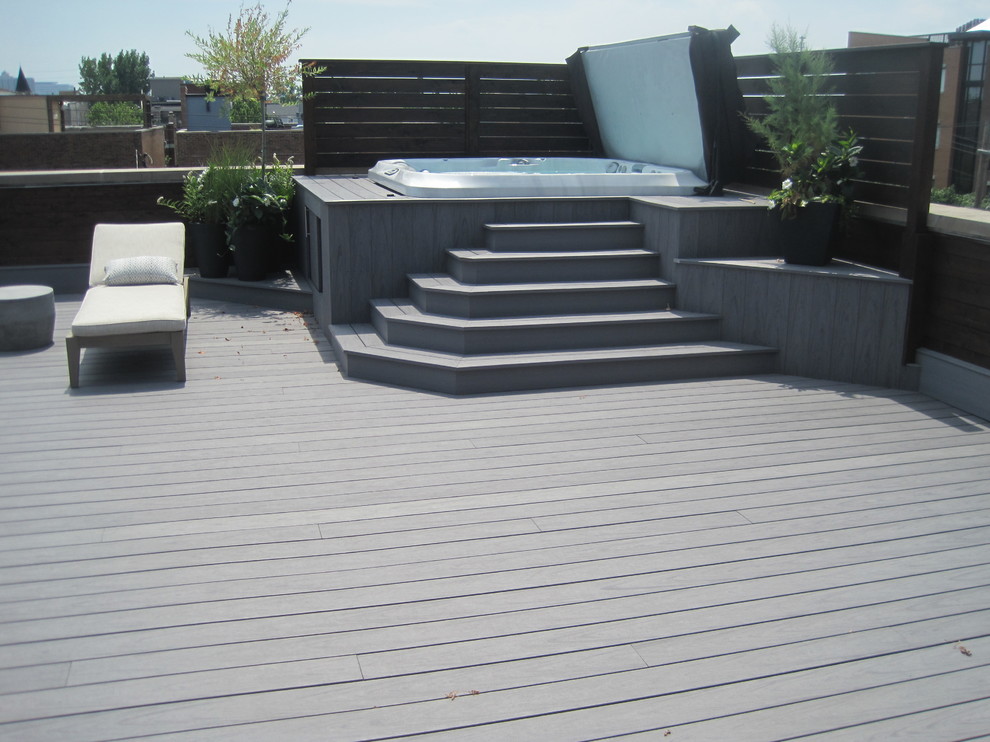 Expansive contemporary rooftop deck in Chicago with a water feature and a roof extension.