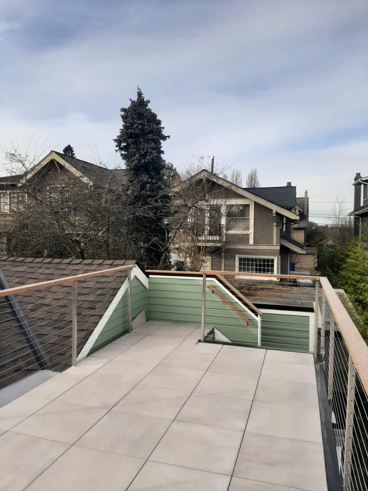 シアトルにあるお手頃価格の中くらいなコンテンポラリースタイルのおしゃれな屋上のデッキ (日よけなし、ワイヤーの手すり、屋上) の写真
