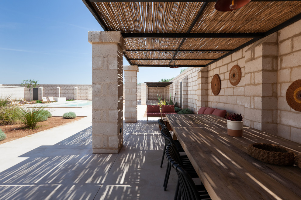 Design ideas for a mediterranean verandah in Other with concrete pavers and a pergola.