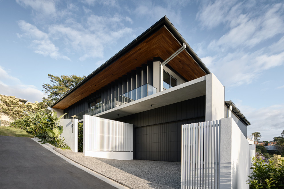 This is an example of a mid-sized contemporary two-storey black house exterior in Brisbane with wood siding.