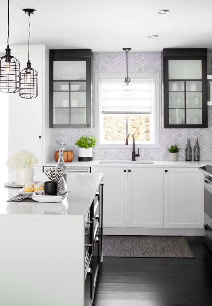 Inspiration for a transitional dark wood floor kitchen remodel in Montreal with an undermount sink, black cabinets, quartz countertops, gray backsplash, ceramic backsplash, an island and glass-front cabinets