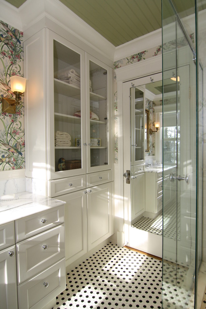 Inspiration for a small traditional bathroom in New York with glass-front cabinets and white cabinets.
