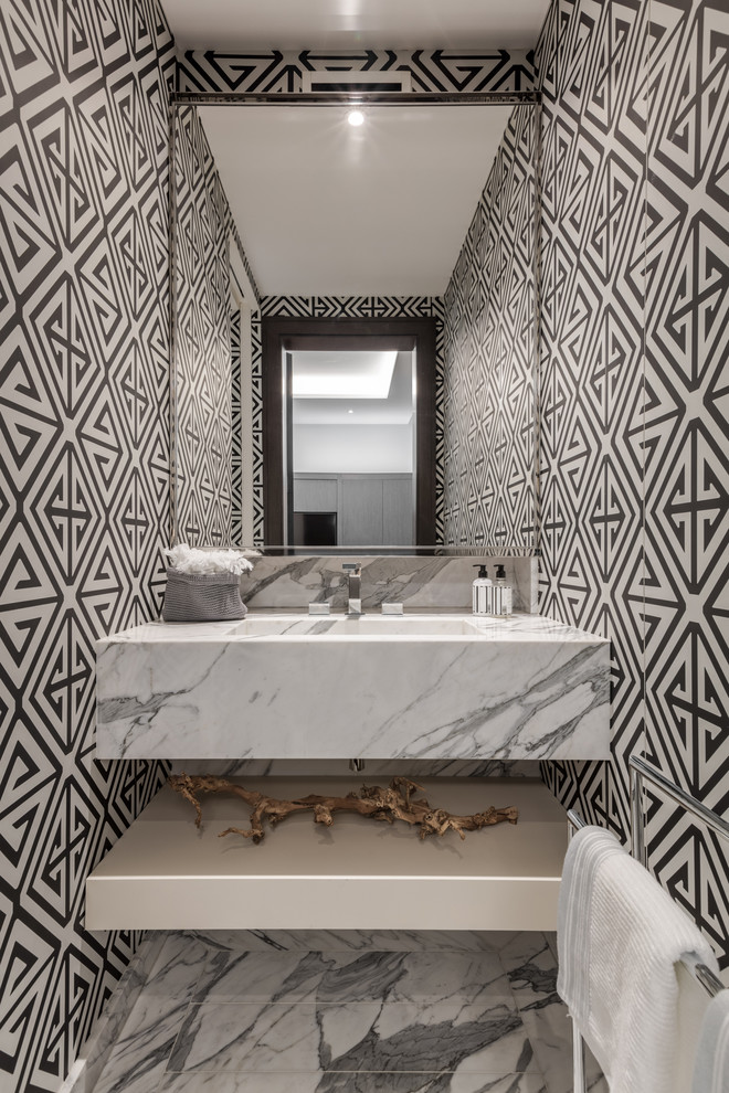 Design ideas for a contemporary powder room in London with multi-coloured walls, an integrated sink, marble benchtops, grey floor and white benchtops.